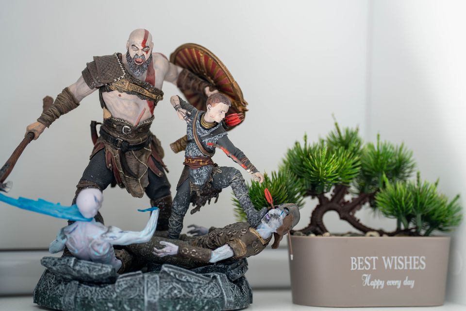 Sculpted warrior figure and young archer figure posed together on a stone-effect base